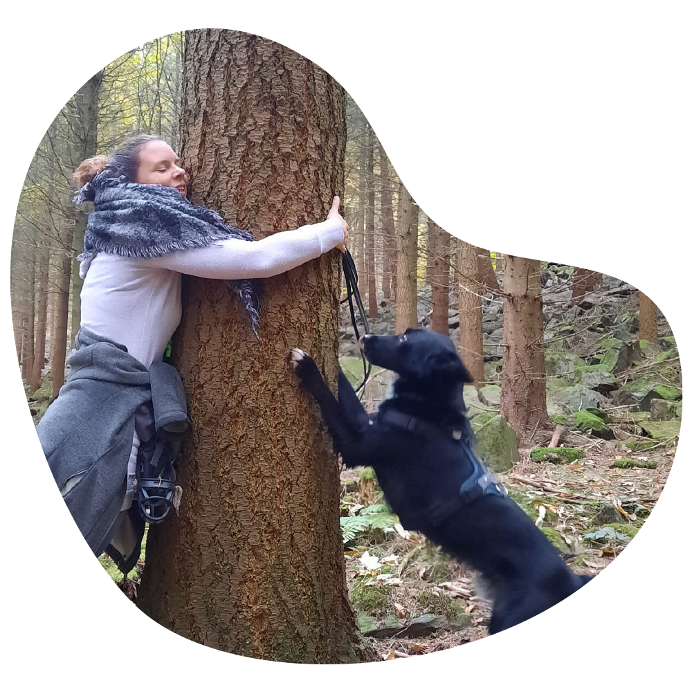 Leontien Vogels umarmt einen Baum mit Hund